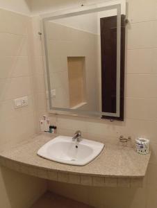 eine Badezimmerablage mit Waschbecken und Spiegel in der Unterkunft Holiday One Hotel & Suites in Karatschi