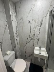a bathroom with a white toilet and a sink at Cozy en-suite 15 minutes from Heathrow Airport by car in South Ruislip Station
