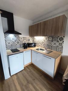 a small kitchen with white cabinets and a sink at Studio 4 pers Aux Angles in Les Angles +12 photos
