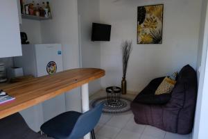 a kitchen with a counter and a chair and a desk at Lantana in Sainte-Anne