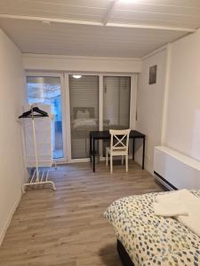 a bedroom with a bed and a desk and a table at Ferienwohnung Biberach an der Riß in Biberach an der Riß