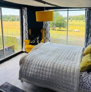 a bedroom with a large bed and a large window at Outlook farm cabin firepit in Hertford