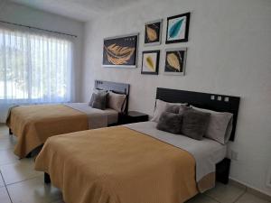 - 2 lits dans une chambre d'hôtel ornée de peintures murales dans l'établissement CASA MYAA, casa para noche, día, fin de semana, semana y mes, à Cuernavaca 5 autres photos