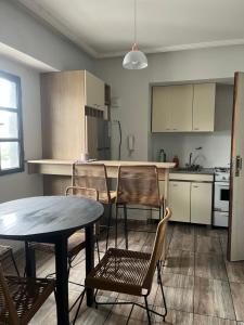 Depto San Lorenzo y Alberdi في سان ميغيل دي توكومان: مطبخ مع طاولة وكراسي في الغرفة