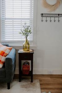 eine Vase Blumen auf einem Tisch neben einer Couch in der Unterkunft Bird-in-Hand Haven in Bird in Hand