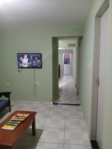 un salon avec une télévision au mur dans l'établissement Casa ou Quartos, à Surubim