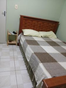 une chambre avec un lit avec une couverture à carreaux dans l'établissement Casa ou Quartos, à Surubim