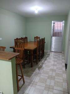une salle à manger avec une table et des chaises en bois dans l'établissement Casa ou Quartos, à Surubim