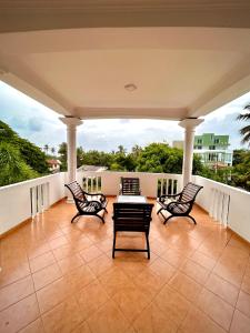 eine Terrasse mit Stühlen und einem Tisch auf einem Balkon in der Unterkunft French Residence Tangalle in Tangalle