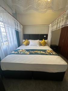 a bedroom with a large bed with yellow pillows at Serene Lakeside Haven in Kisumu
