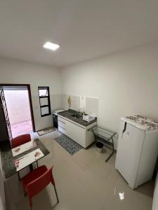 a kitchen with a red chair and a refrigerator at Apartamento no centro próximo a Jk in Palmas