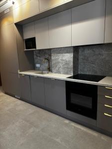 une cuisine avec des armoires blanches et un évier dans l'établissement Rabczański Taras, à Rabka-Zdrój 6 autres photos