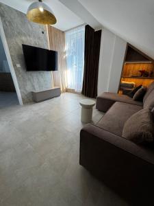 a living room with a couch and a flat screen tv at Rabczański Taras z jacuzzi i otwieranym dachem in Rabka-Zdrój