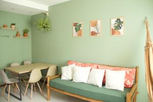 a living room with a green couch and a table at Casa Luminah in Itacaré