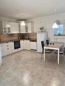 eine Küche mit weißen Schränken und einem Tisch mit Stühlen in der Unterkunft Ferienwohnung Am Steinberg in Nauendorf