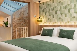 a bedroom with a large white bed with green pillows at Casa Carmela Baiona in Baiona