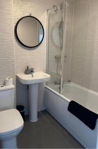 a bathroom with a sink and a tub and a toilet at Margam's Gloucester House for Business Travellers in Cheltenham