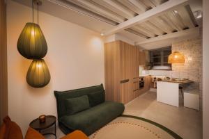 a living room with a green couch and a kitchen at Casa Carmela Baiona in Baiona +21 photos