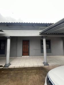 una casa con dos columnas y una puerta en Makers lodge Bnb, en Nelspruit