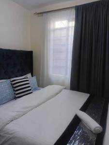 Un dormitorio con una cama grande con ventana. en Makers lodge Bnb, en Nelspruit