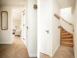 a hallway with white walls and a staircase with a mirror at Pretty Holiday Home in De Koog Texel with Garden in Westermient