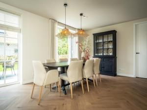 a dining room with a table and chairs at Pretty Holiday Home in De Koog Texel with Garden in Westermient +25 photos