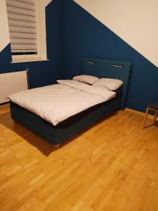 a bed in a room with a blue wall at Apartment with 4 Rooms in Golling