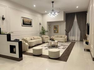 ein großes Wohnzimmer mit Sofas, einem Tisch und Stühlen in der Unterkunft Holiday One Hotel & Suites in Karatschi