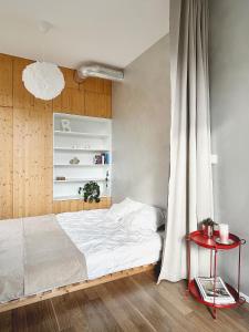 une chambre avec un lit blanc et une table rouge dans l'établissement FRENCHCORNER apartment, à Brno 11 autres photos