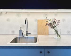 - un comptoir de cuisine avec un évier et un vase de fleurs dans l'établissement FRENCHCORNER apartment, à Brno