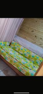 a bed with a mattress with flowers on it at Bombinhas, Casa mobiliada 1 quarto in Bombinhas