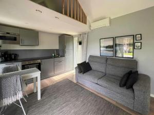 a living room with a couch and a kitchen at Mini House With Sandy Beach And Sauna in Olofstorp
