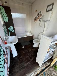a bathroom with a sink and a toilet and a tub at Serendipia Hostel Punta Rubia in La Pedrera +77 photos