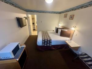 a hotel room with a bed and a television at Ocean Breeze Motel in Florence