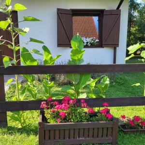ein Holzzaun mit Blumen in einem Blumenkasten in der Unterkunft Sielsko Anielsko Uniejów- domki całoroczne in Uniejów + 16 Fotos