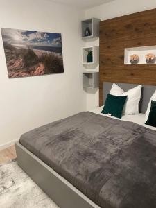 une chambre avec un grand lit avec des oreillers verts dans l'établissement Zentrale Wohnung 1OG mit WLAN & Kaffee, à Paderborn