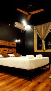 un grand lit dans une chambre avec un ventilateur dans l'établissement Goan Cozy 2 Bedroom Abode, à Calangute