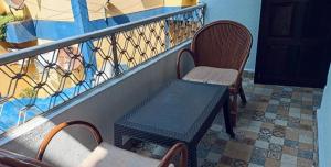 un balcon avec une table et des chaises sur un balcon dans l'établissement Goan Cozy 2 Bedroom Abode, à Calangute
