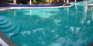 une grande piscine avec de l'eau bleue dans l'établissement Goan Cozy 2 Bedroom Abode, à Calangute 3 autres photos