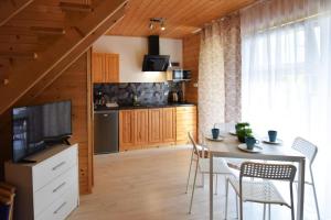 a kitchen and dining room with a table and chairs at Comfortable holiday homes with terraces in Przewłoka