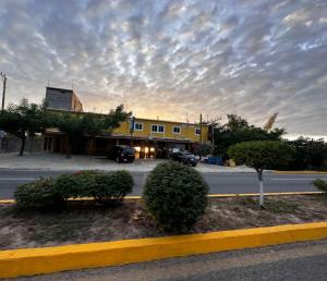 a building on a street with a cloudy sky at Brisa del mar #7 in Puerto Escondido