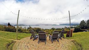 d'une table et de chaises avec vue sur le lac. dans l'établissement Cabaña Luz de Luna, à Cuítiva