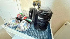 eine Kaffeemaschine und zwei Tassen auf einer Theke in der Unterkunft Armadillo Guest House- Adults Only in Edinburgh