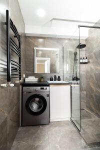 a bathroom with a washing machine and a sink at Brand New Flat Near Cafes and Shops I Full Ameneties in Floreşti