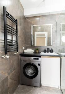a washer and dryer in a small bathroom at Brand New Flat Near Cafes and Shops I Full Ameneties in Floreşti