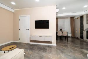 a living room with a tv on a wall at Brand New Flat Near Cafes and Shops I Full Ameneties in Floreşti