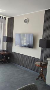 a waiting room with two tables and a television on the wall at Geluk in Bettingen in Bettingen
