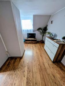 an empty living room with a wooden floor at Töpferhäuschen Tangermünde in Tangermünde