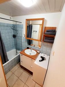 a bathroom with a sink and a bath tub at Appart-hôtel original facile d'accès in Chapareillan