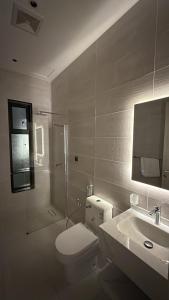 a bathroom with a toilet and a shower and a sink at Elegant and classy apartment in Al Faisaliah neighborhood in Jeddah +9 photos